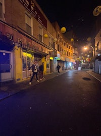people walking down a street at night